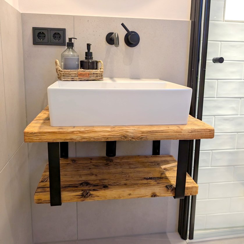 Waschtischunterschrank im Bad. Holz / Massivholz / Altholz, Stahlträger schwarz, Aufsatzwaschtisch weiß, schwarze Wand-Auslaufarmatur